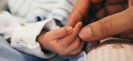 la main d'un bébé et celle d'un parent illustrent les rencontres sur la parentalité