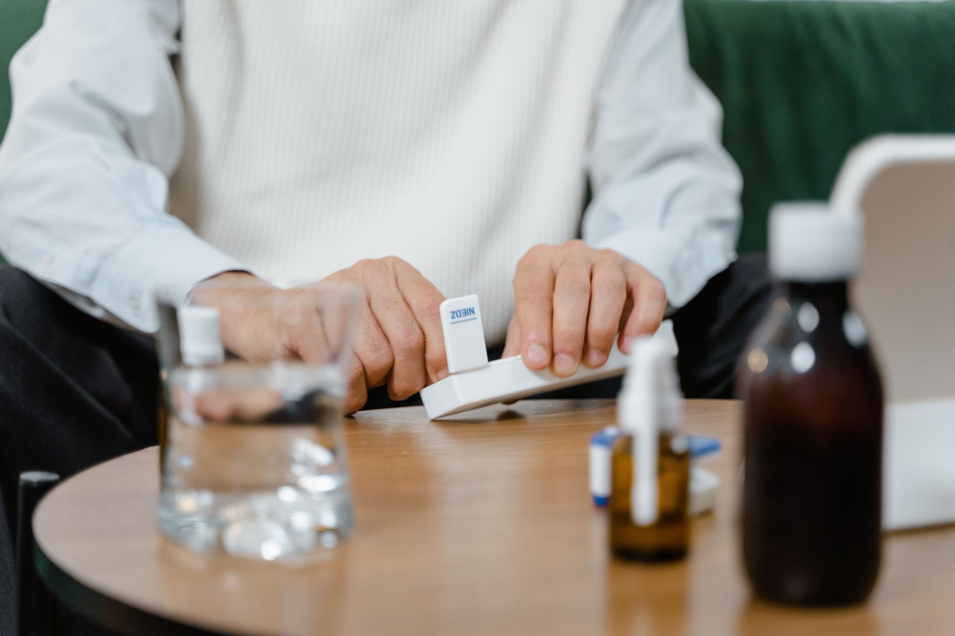 Une personne âgée prépare ses doses de médicaments à domicile, mettant l'accent sur les soins de santé et les solutions de télésanté.